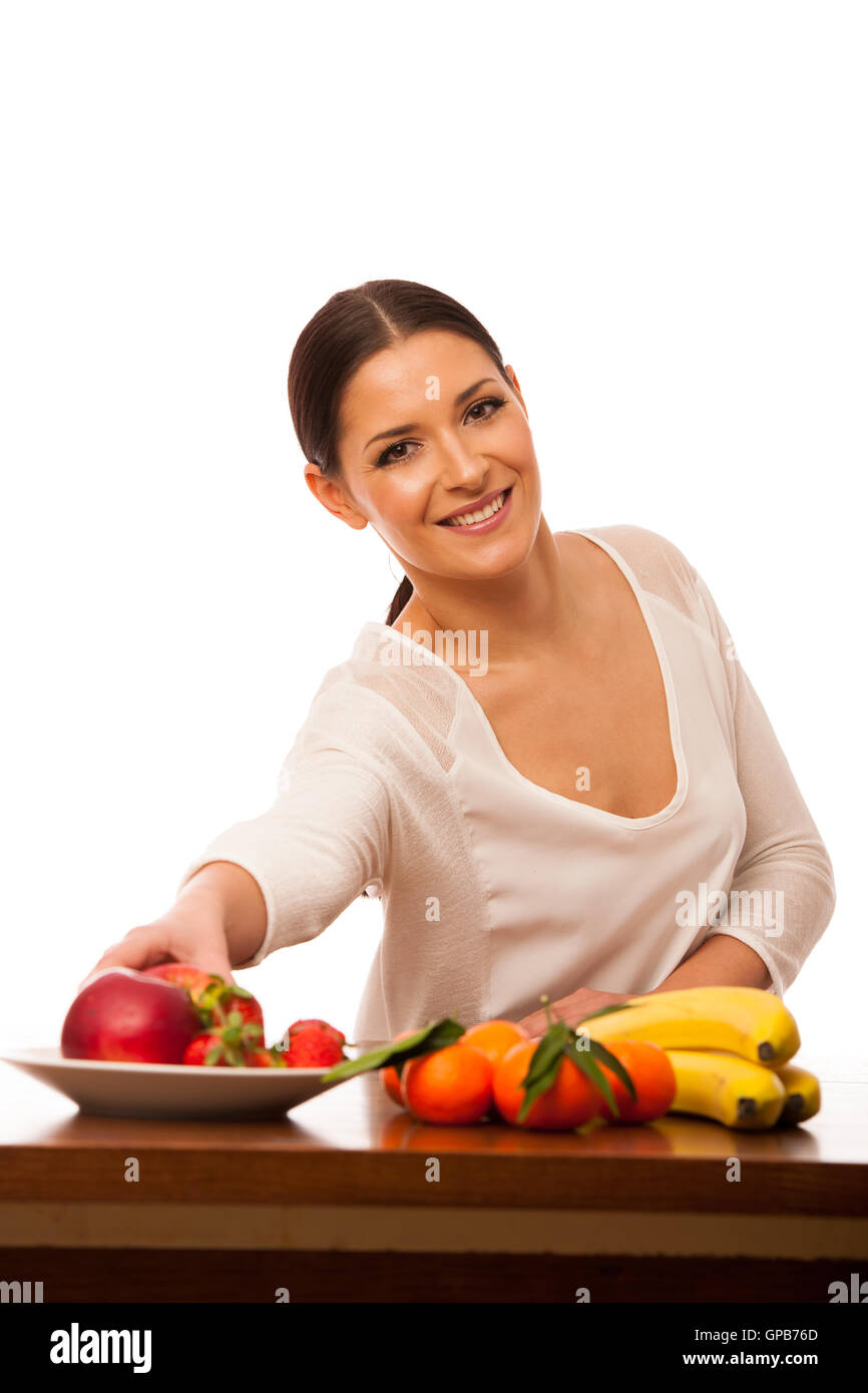 Femme derrière la table pleine de fruits frais la promotion de choix de vie isolated over white. Banque D'Images