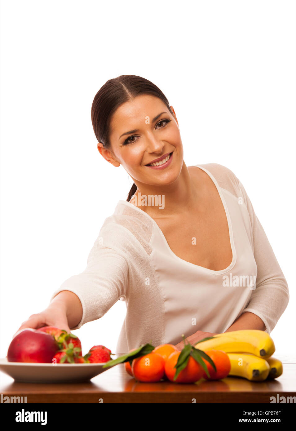 Femme derrière la table pleine de fruits frais la promotion de choix de vie isolated over white. Banque D'Images