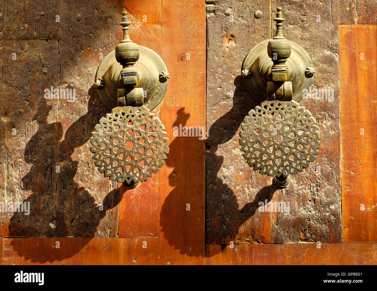 Poignées de porte en bronze d'ornement décoré les portes de palais marocain au soleil du soir Banque D'Images