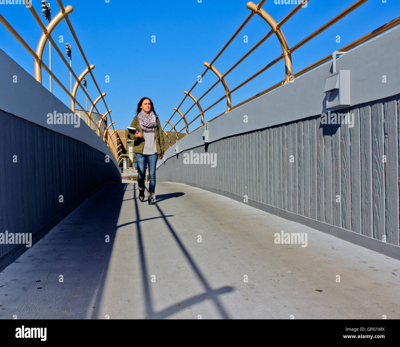 Female college student walking avec de longues ombres dans la classe. Banque D'Images