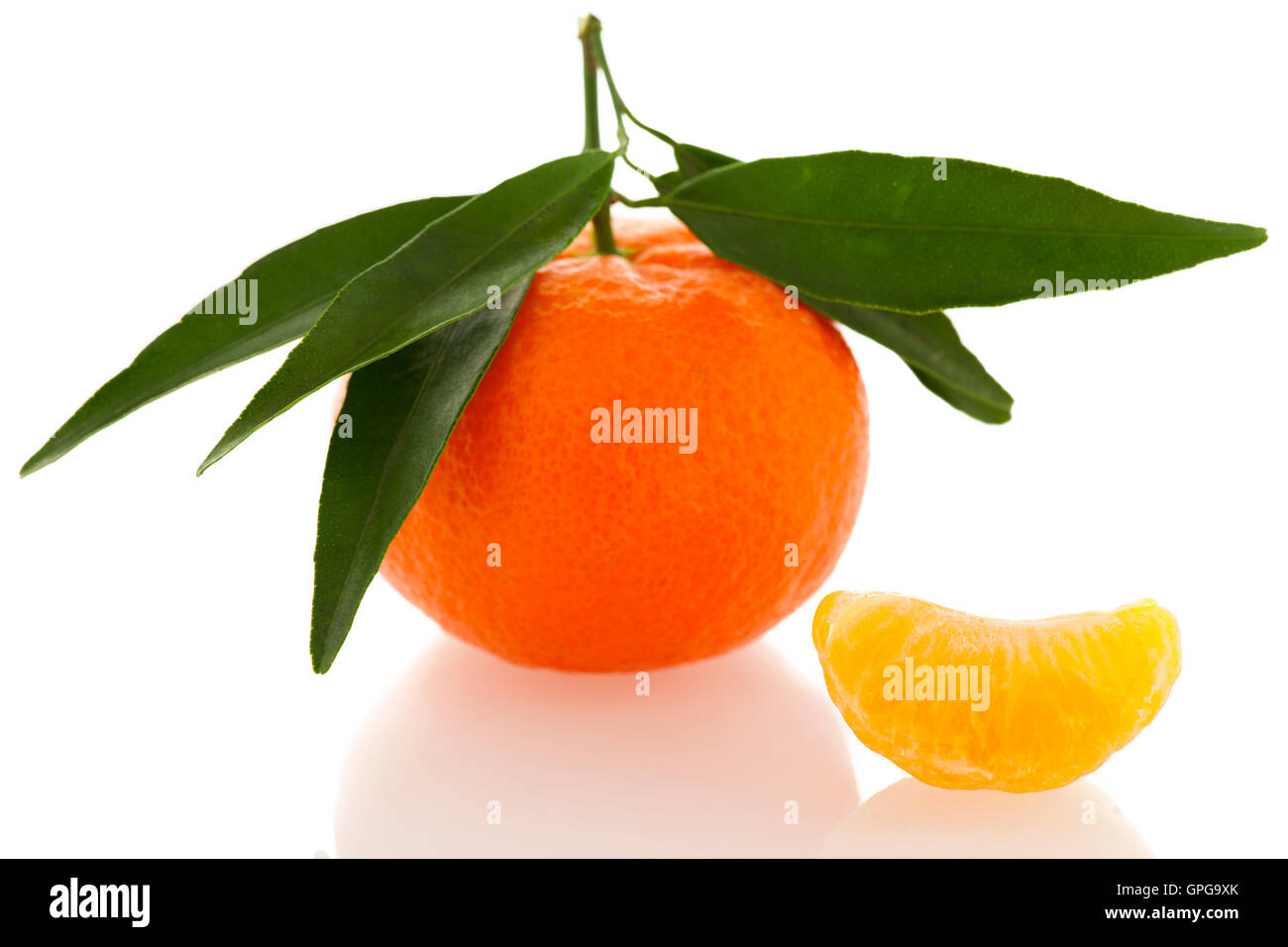 Agrumes mandarin orange fraîches non pelées avec feuilles vertes et la moitié des tranches de fruits pelés isolated over white background. Tasty swe Banque D'Images