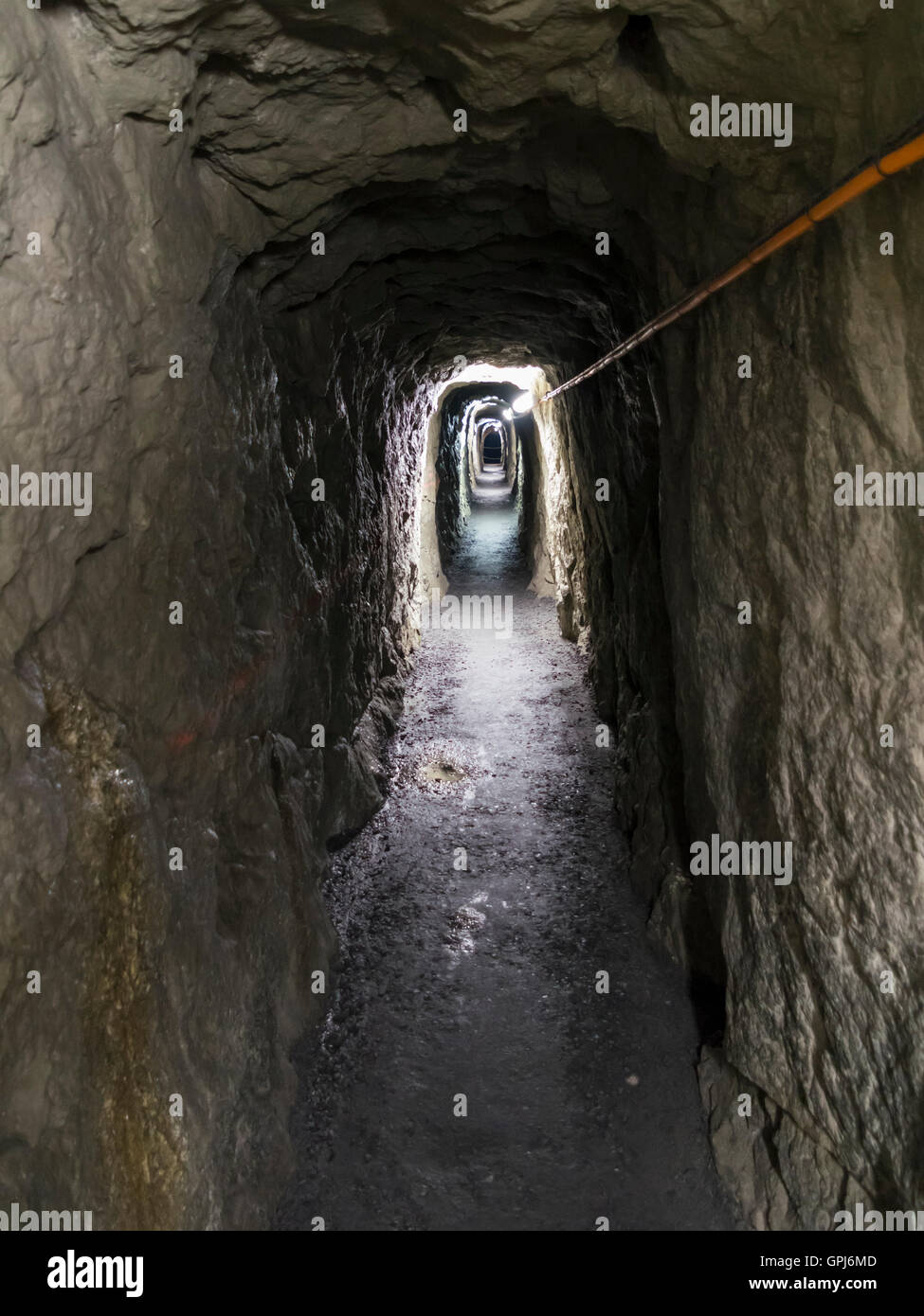 Long et étroit tunnel faiblement éclairé dans un bunker dans les Alpes suisses. Banque D'Images