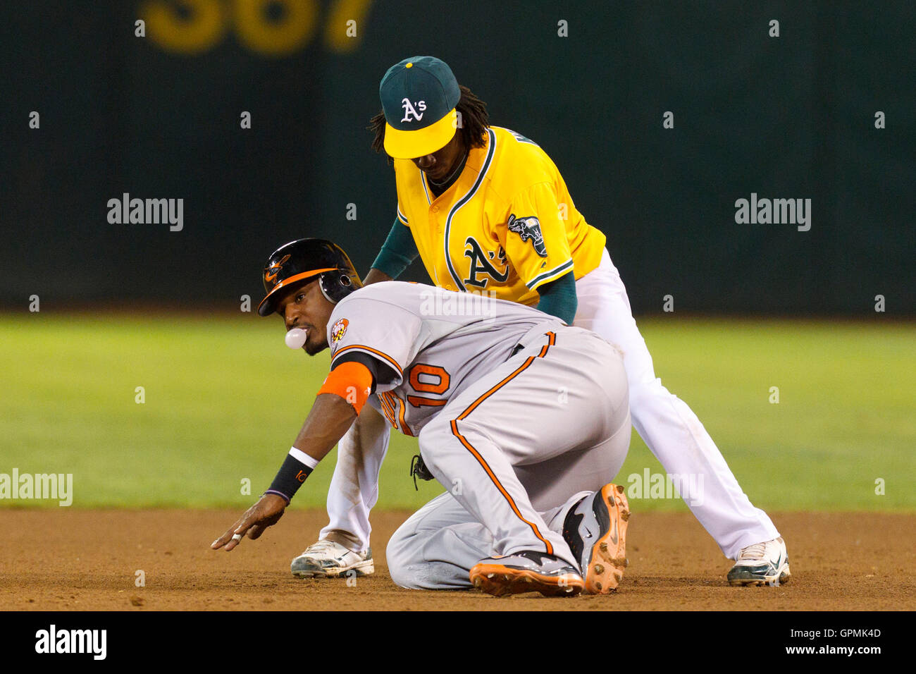 15 août, 2011 ; Oakland, CA, USA ; Baltimore Orioles champ centre Adam Jones (10) évite une pickoff tentative de seconde base par Oakland Athletics le deuxième but Jemile Weeks (retour) au cours de la septième manche chez O.co Coliseum. 6- Oakland défait Baltimore Banque D'Images