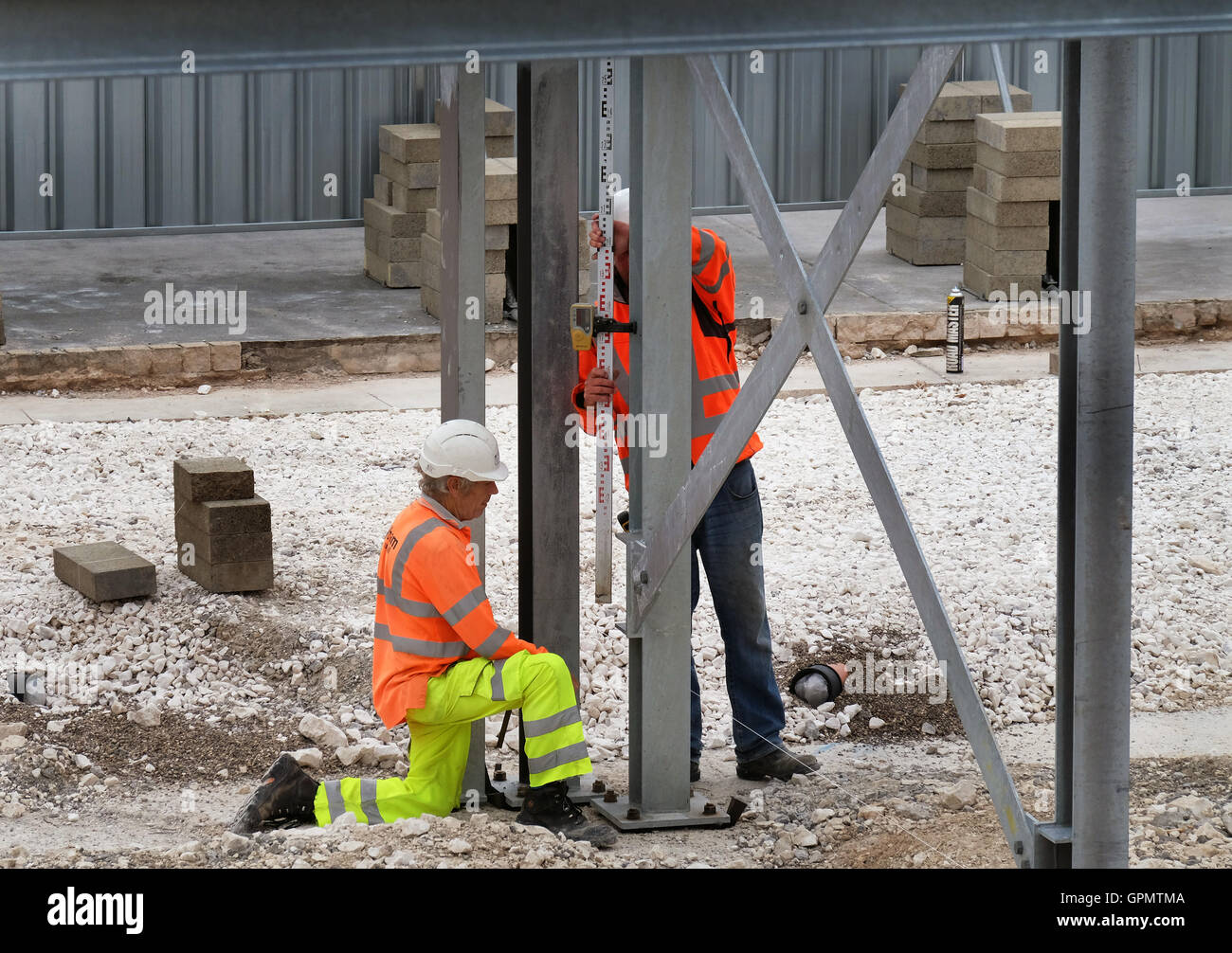 Contrôle de l'alignement des travailleurs de l'acier sur la structure du bâtiment. Banque D'Images