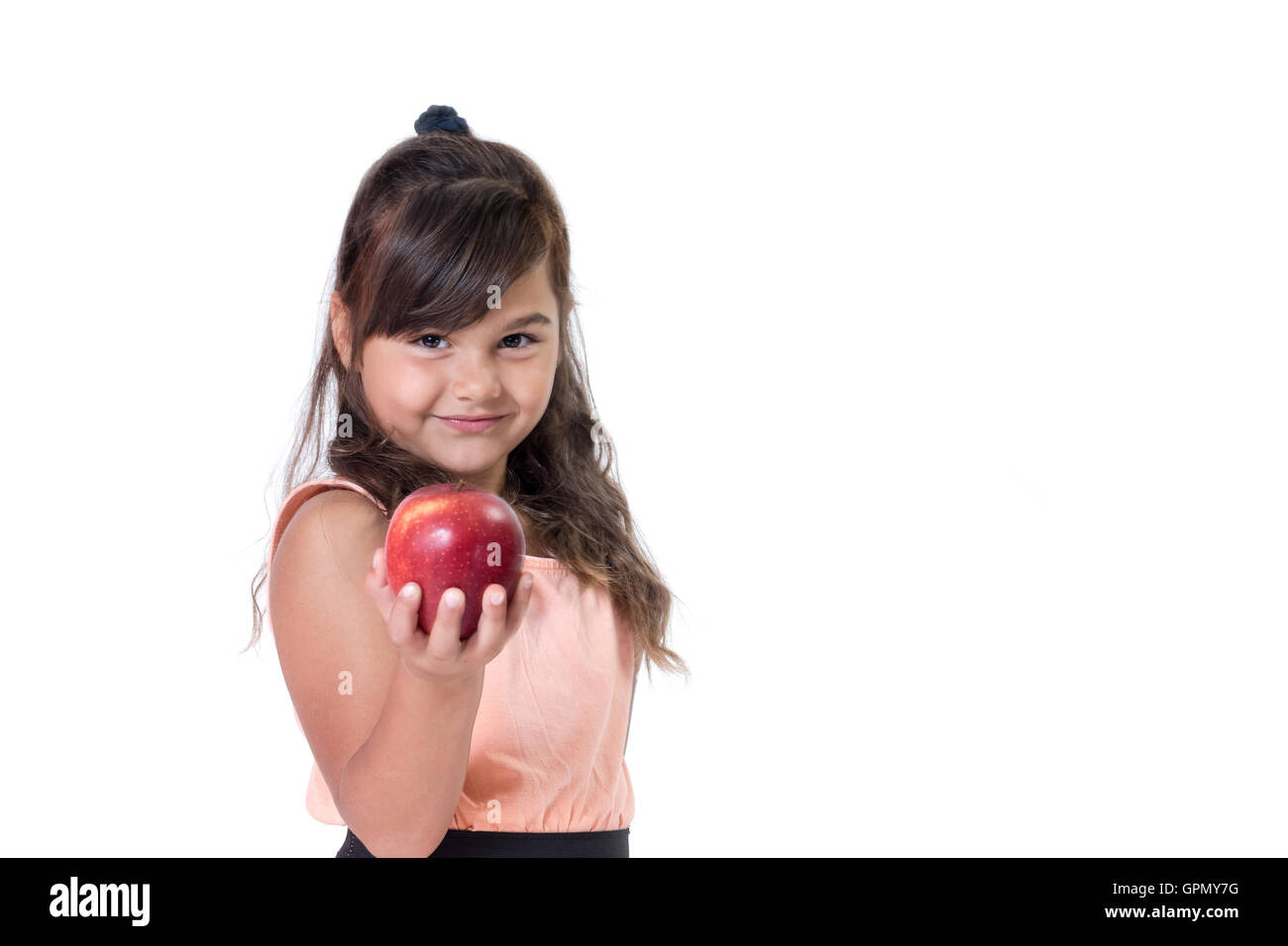 Jolie petite fille est tenant une pomme rouge dans la main. Tout est sur un fond blanc. Banque D'Images