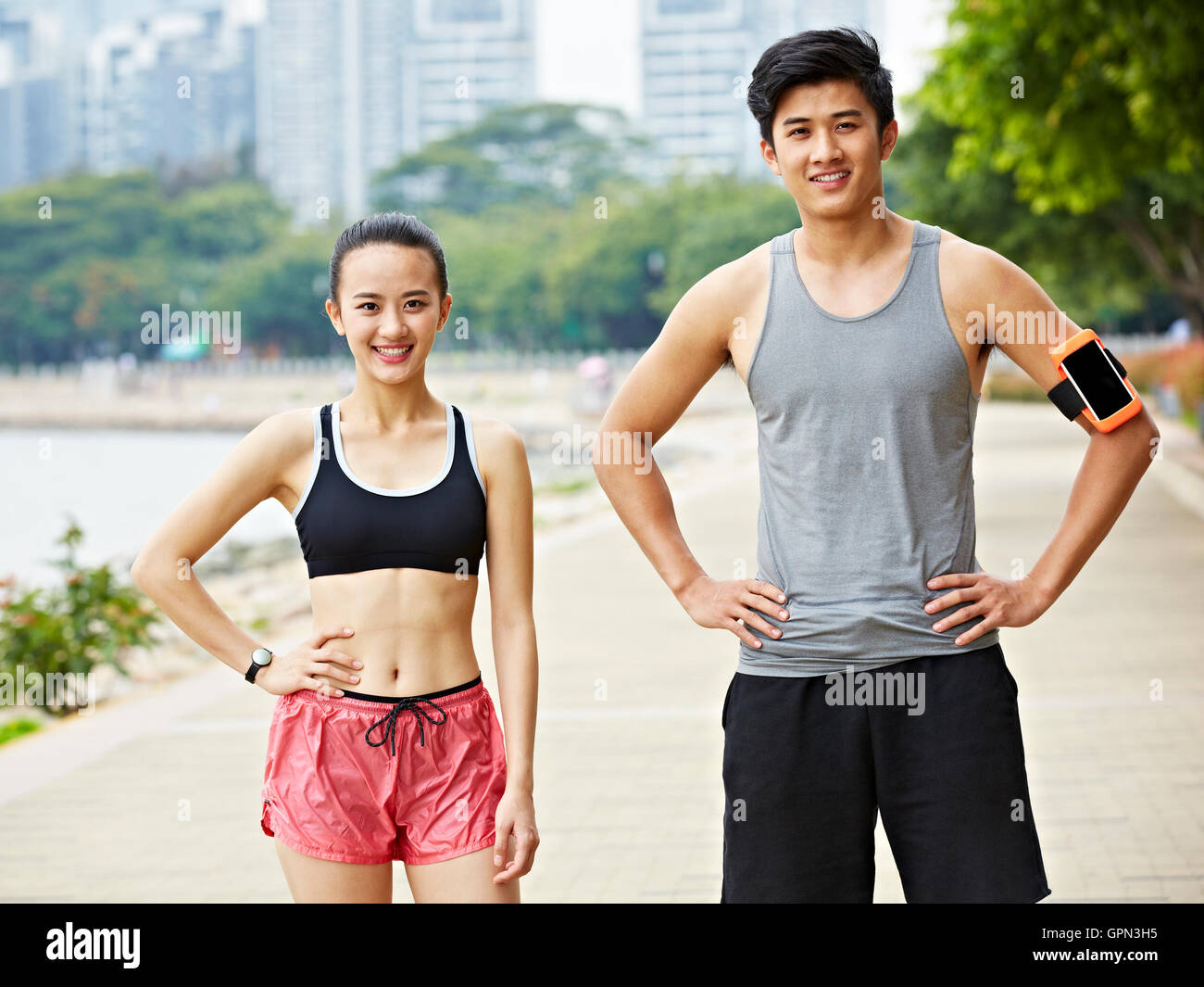 Portrait d'un couple asiatique exerçant dans city park, smiling Banque D'Images