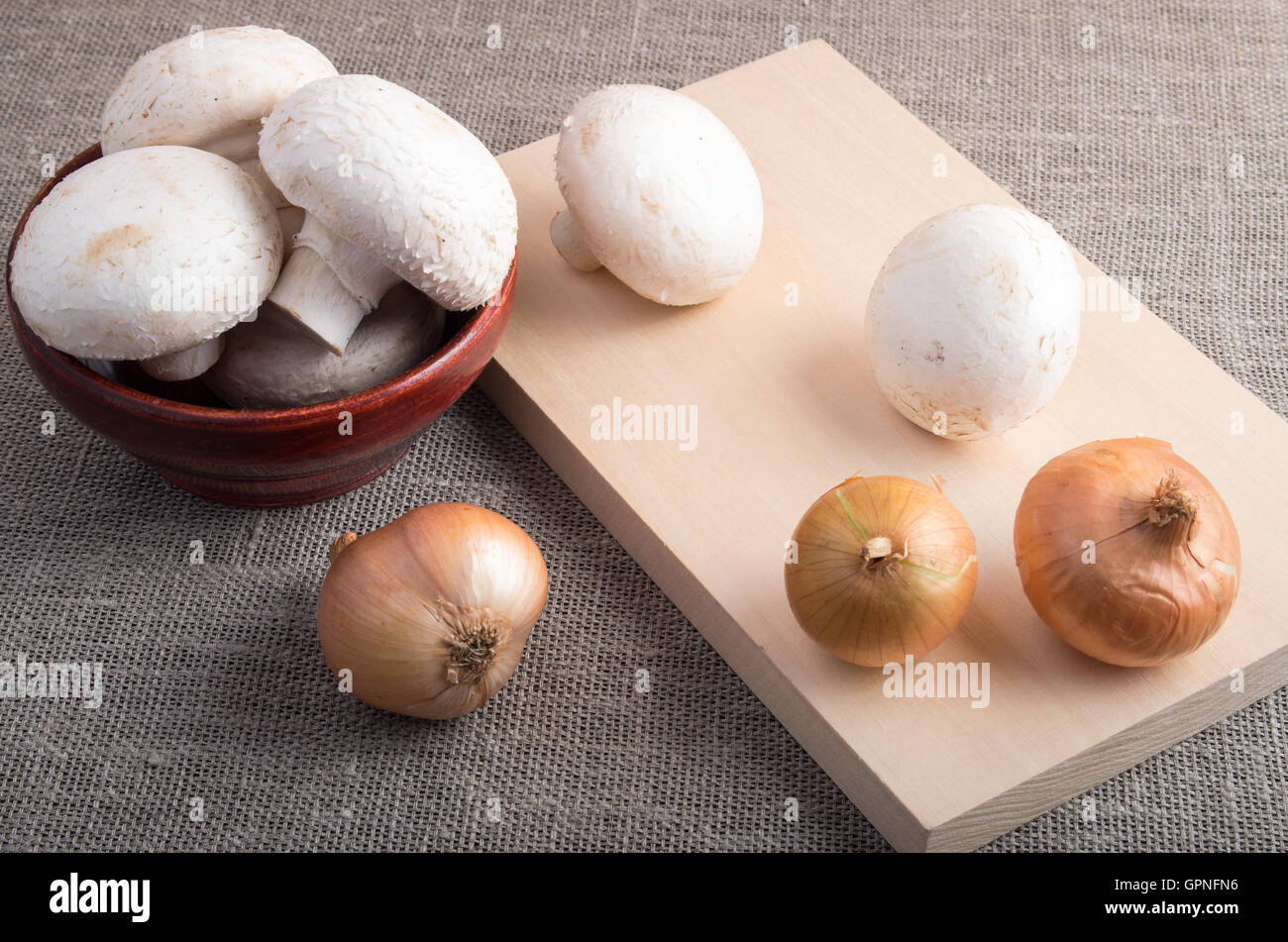 Matières champignon champignons et oignons sur la table, couverte de jute Banque D'Images