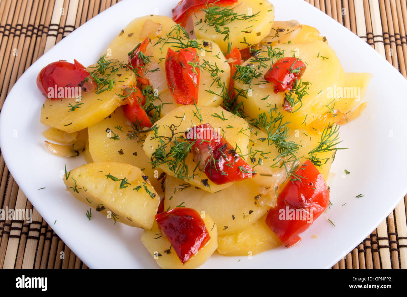 Plat végétarien avec des légumes biologiques - tranches de pommes de terre cuites et les condiments végétaux sur un fond de bois Banque D'Images
