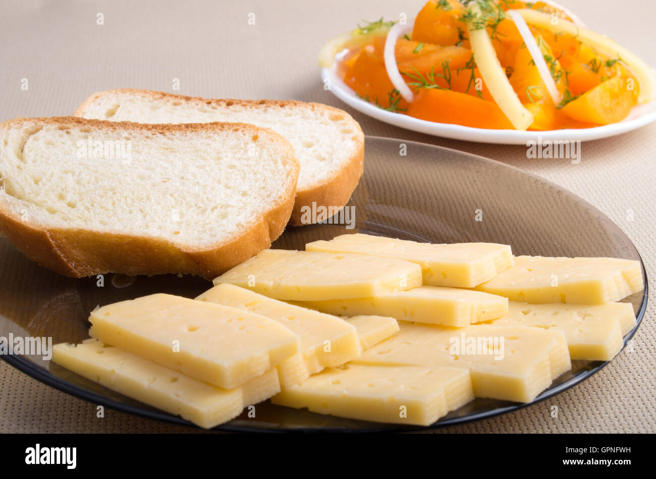Vue rapprochée sur les collations des veggie - une assiette avec des morceaux de pain et de fromage et de légumes avec salade tomate brutes Banque D'Images