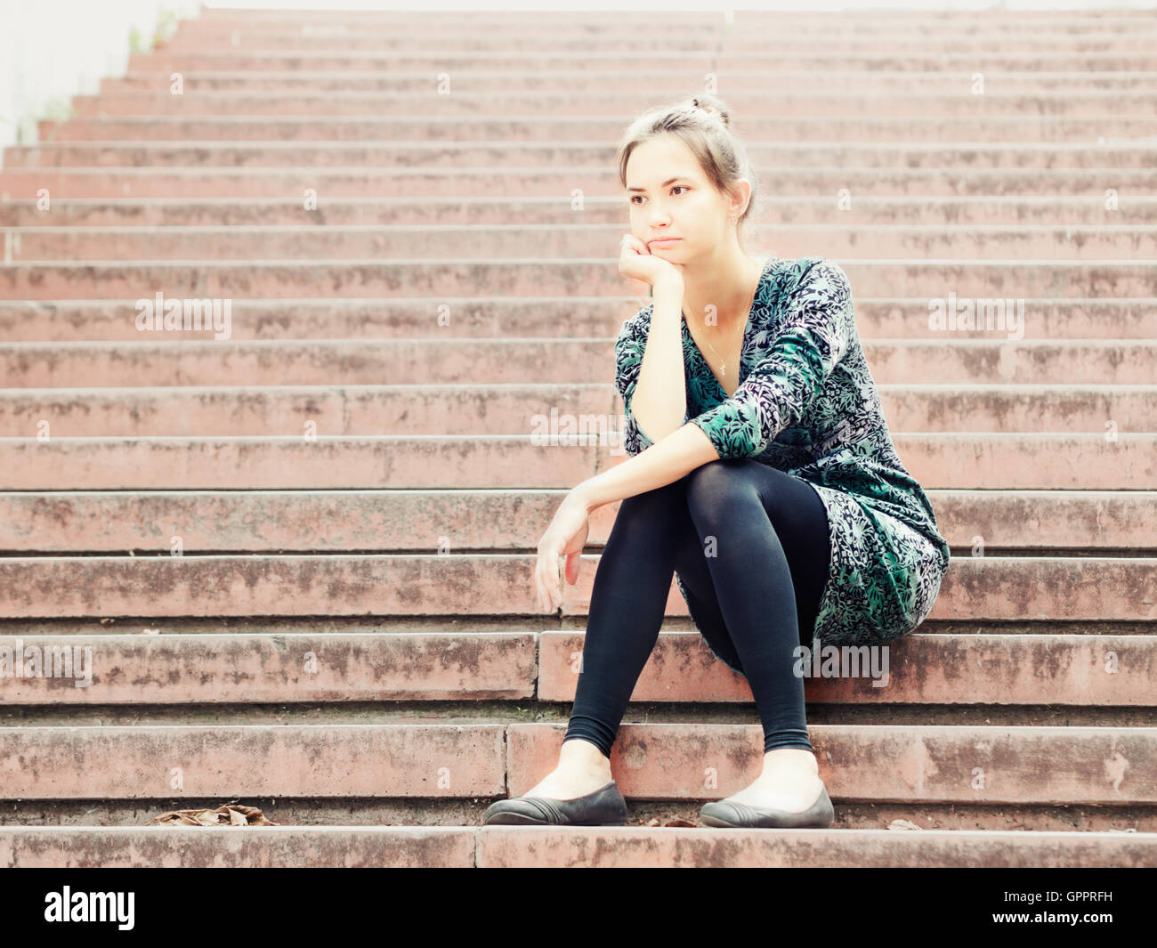 Sad girl sitting on steps Banque D'Images