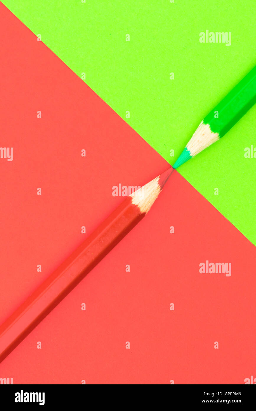 Crayons de couleur vert et rouge et du papier, le contraste de l'image conceptuelle abstraite Banque D'Images