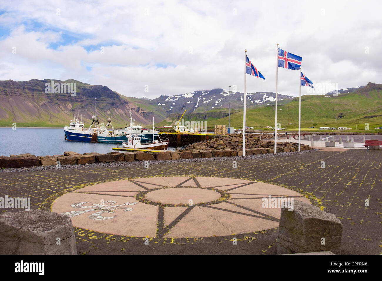 Drapeaux islandais sur le quai avec des bateaux de pêche amarrés dans le port. Grundarfjordur, Péninsule de Snæfellsnes, l'Islande Banque D'Images
