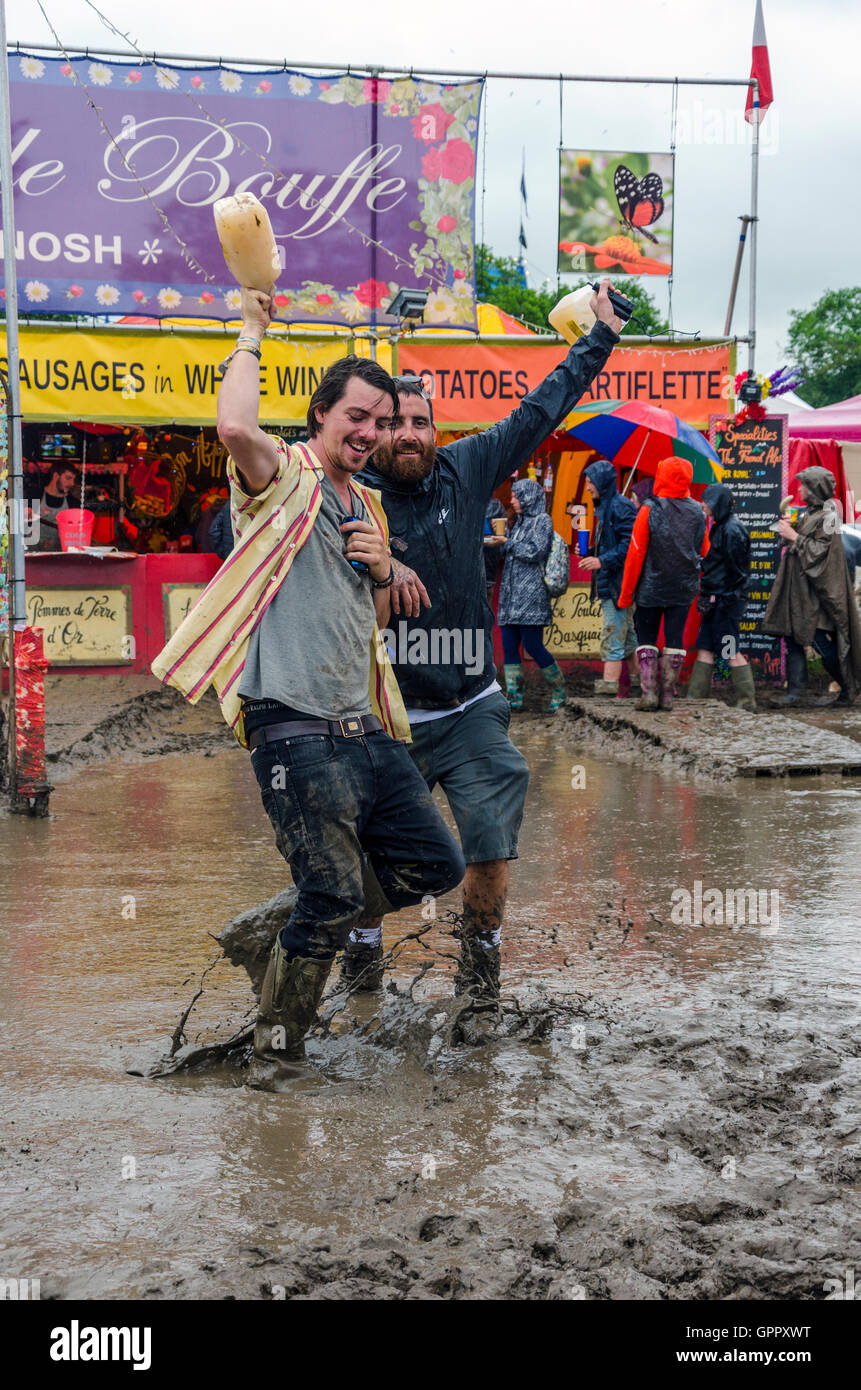 Deux festivaliers vague et faire la lumière de la boue au festival de Glastonbury Banque D'Images