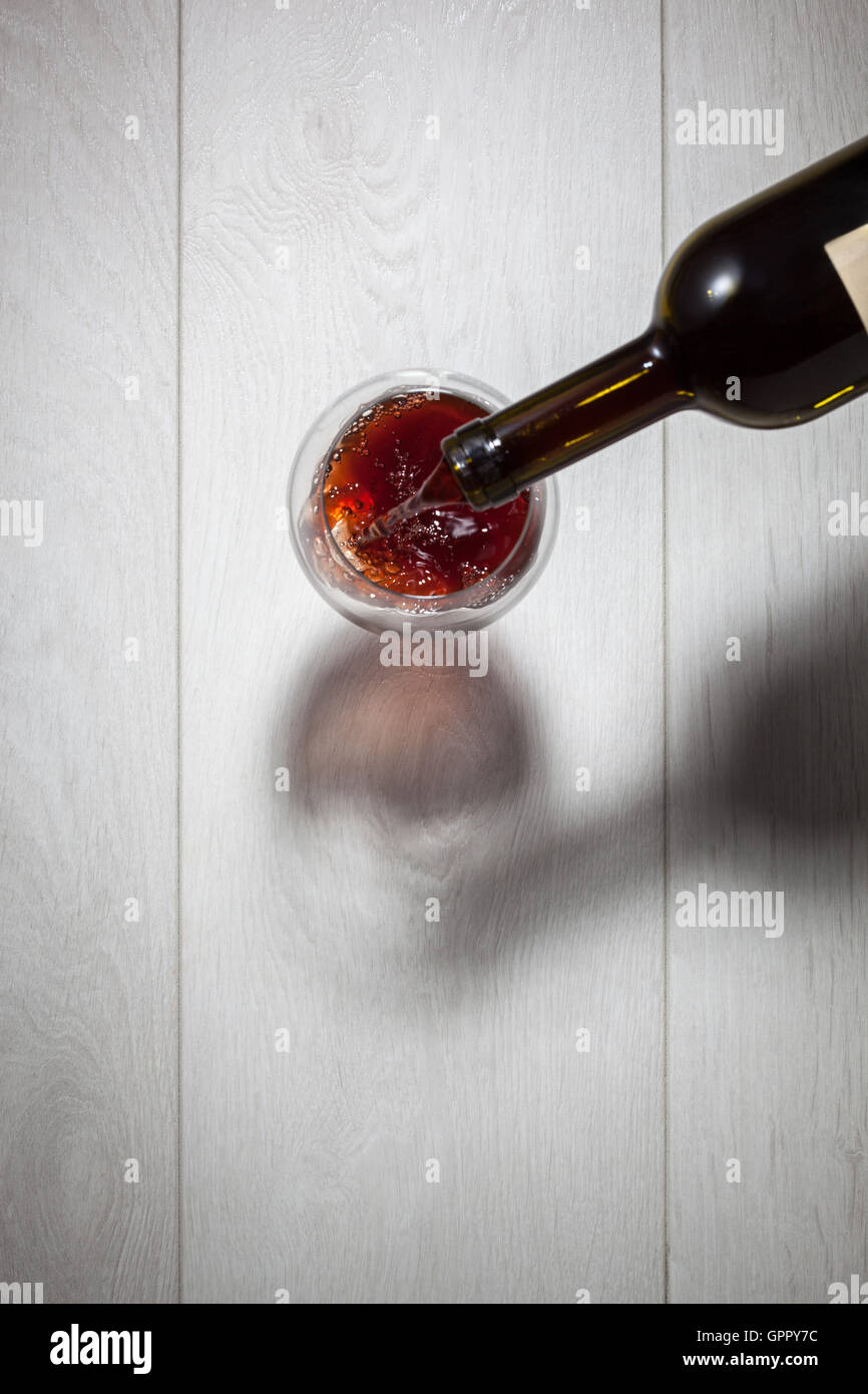 Verser le vin rouge dans le verre de la bouteille Photo Stock - Alamy