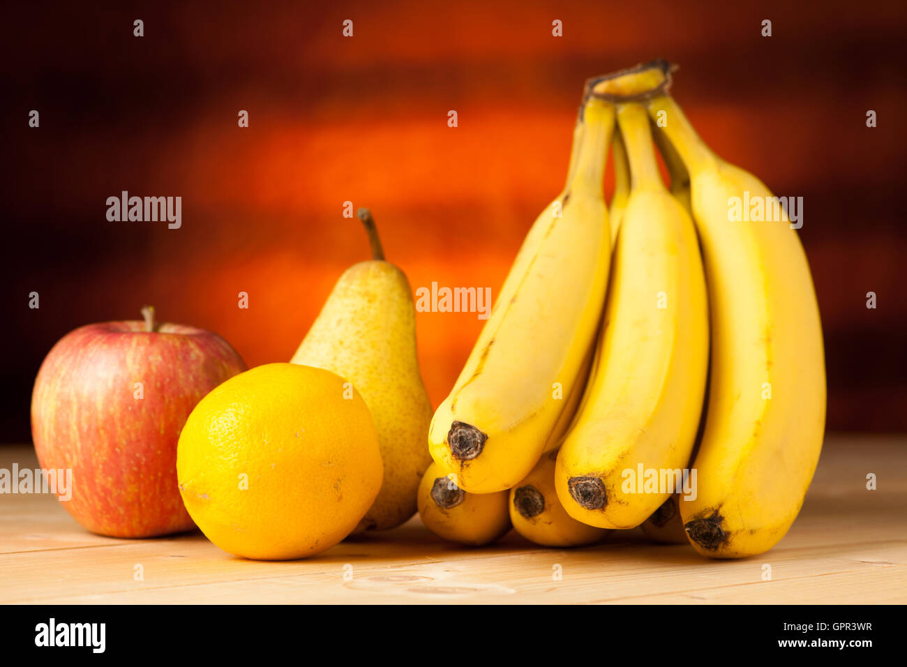 Des fruits sur la table - banane poire pomme et citron sur un bureau en bois Banque D'Images
