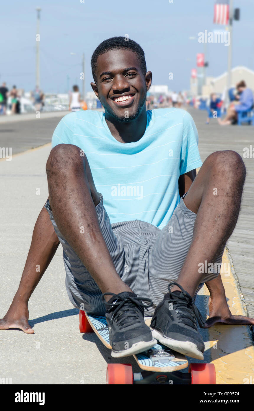 Heureux jeune homme en plein air avec son skateboard Banque D'Images