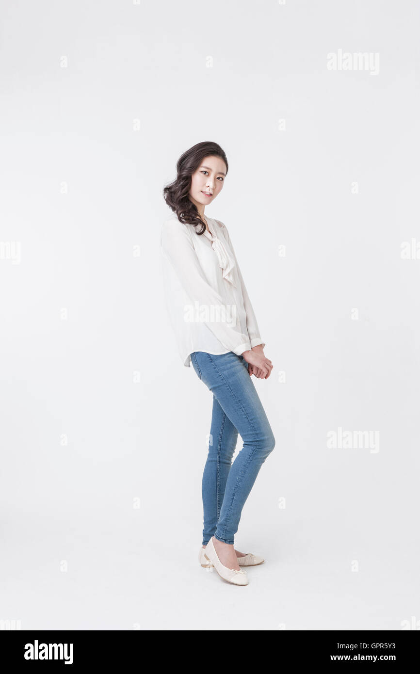 Jeune femme posant en blouse blanche et un jean bleu Banque D'Images