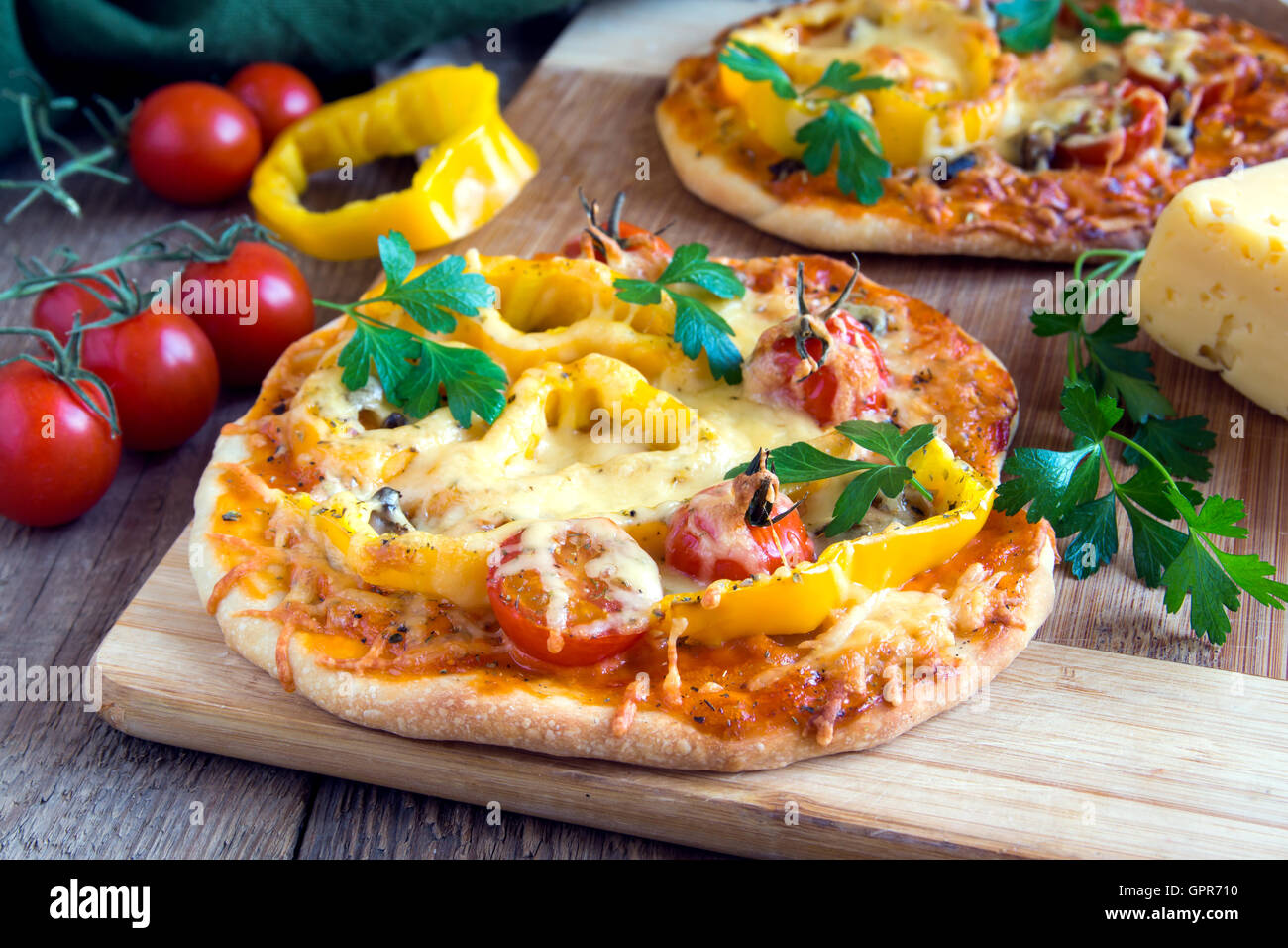 Pizza aux légumes et ingrédients sur conseil cuting en bois Banque D'Images