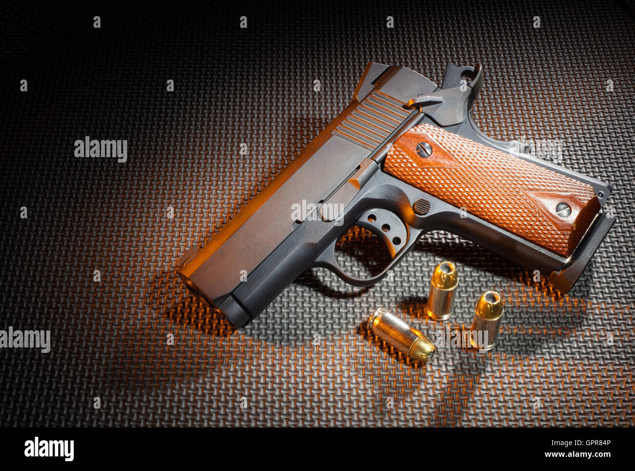 Pistolet sur un fond sombre avec une texture gel orange ci-dessus Banque D'Images