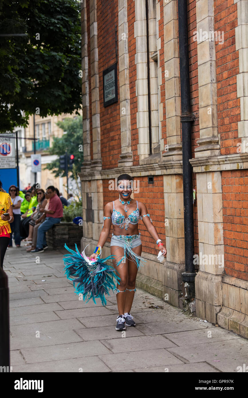 Jeune femme noire marchant à la début de la Notting Hill Carnival avec son costume bleu et Blue Feather head dress Banque D'Images
