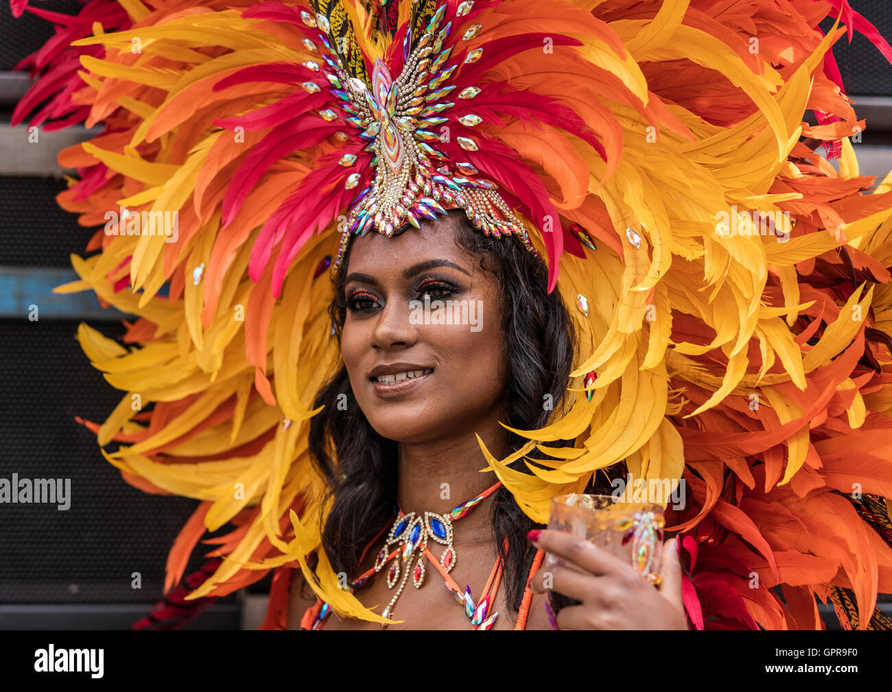 Belle Dame Afro Antillais Noirs portant des costumes de carnaval de Notting Hill et rouge avec plumes orange et jaune. Banque D'Images