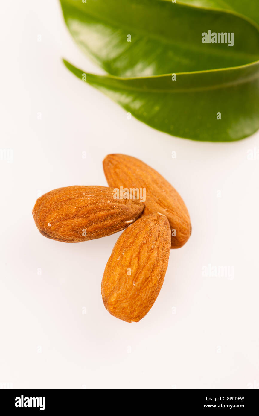 Trois amandes décortiquées, collation saine isolé sur fond blanc. Banque D'Images