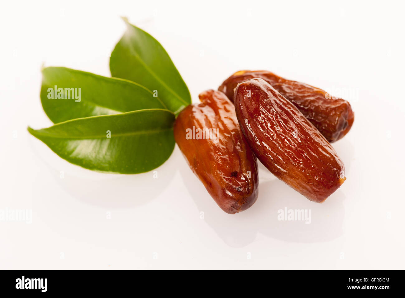 Dattes séchées sucrées des fruits sur feuille verte, désert méditerranée isolated over white. Banque D'Images