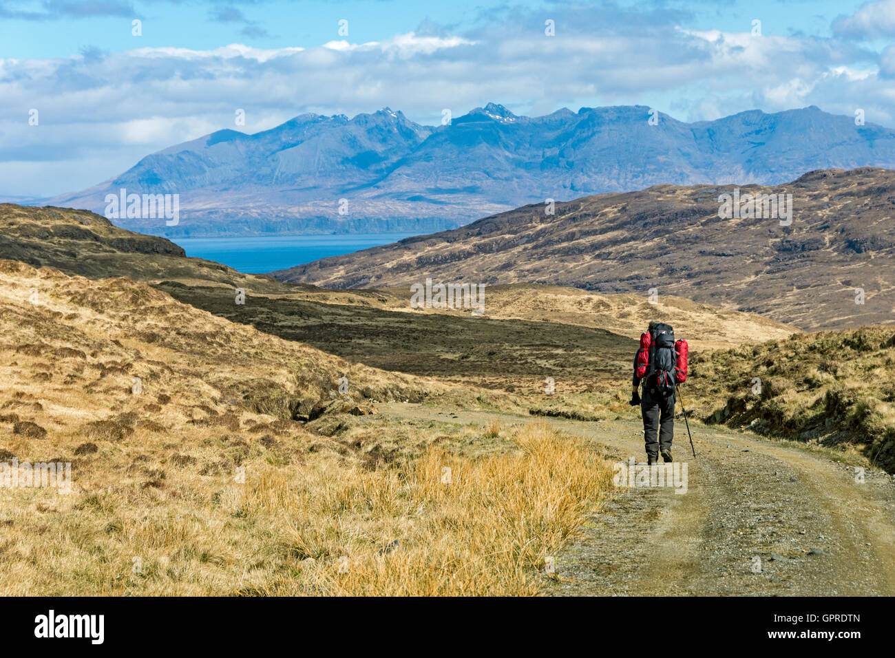 Walker sur la piste à partir de la position de Harris Bay Kinloch, à l'île de Rum, Ecosse, Royaume-Uni. Les Cuillin hills de Skye au loin. Banque D'Images
