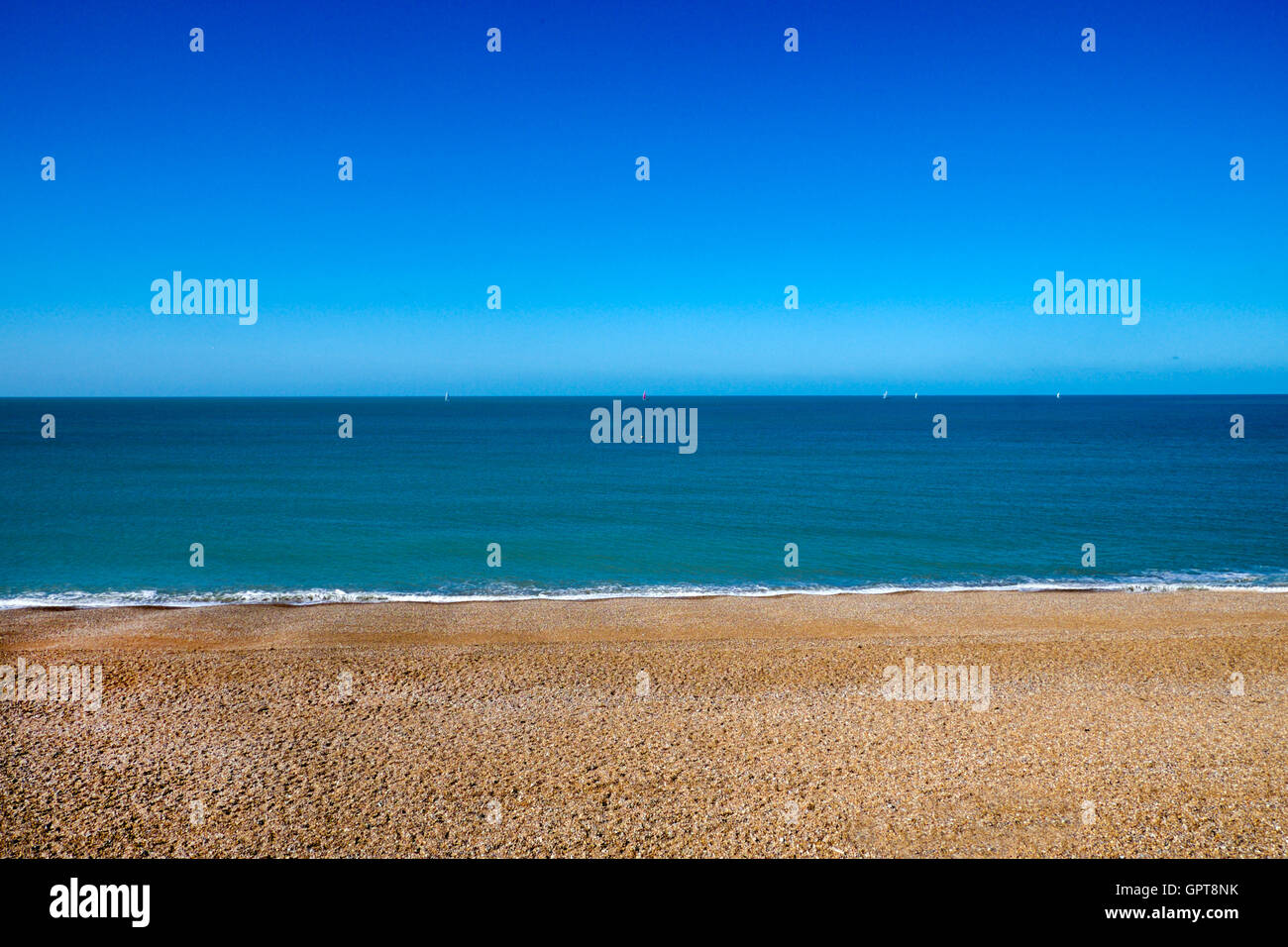 La plage de Seaford, East Sussex, Royaume-Uni. 1 Troisième plage vide jaune, 1 troisième mer bleu clair, 1 troisième ciel bleu clair Banque D'Images