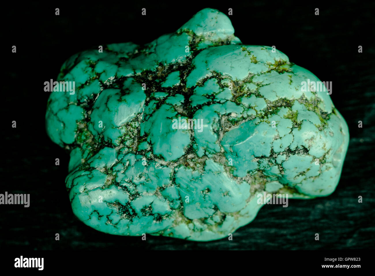 Gemstone turquoise brut isolé sur black rock Banque D'Images