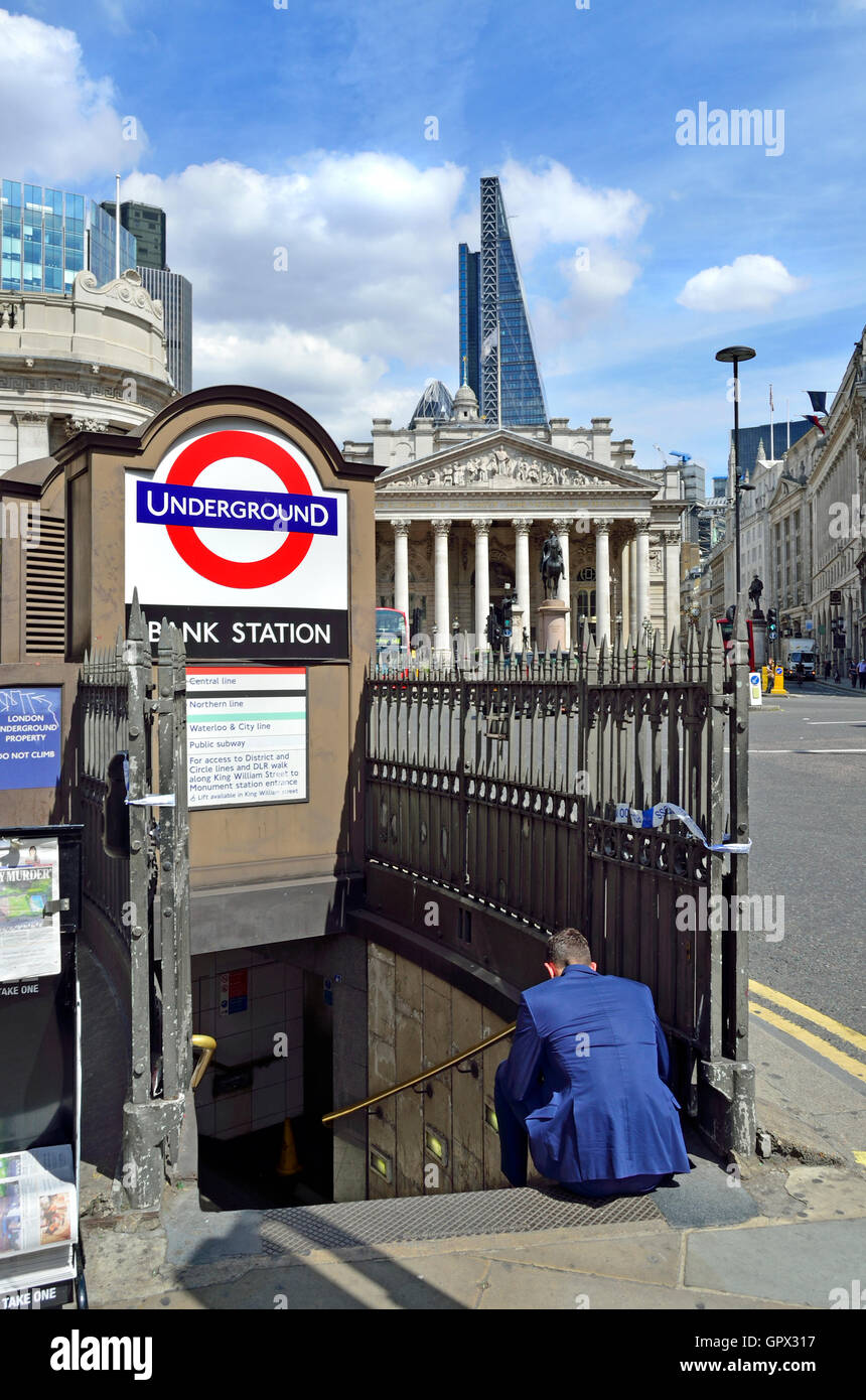 Londres, Angleterre, Royaume-Uni. La station de métro Bank et Royal Exchange - homme sur les étapes en utilisant son téléphone mobile Banque D'Images