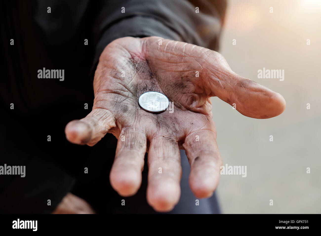 Homme de main mendier de l'argent à cause de la faim dans la lumière du matin Banque D'Images