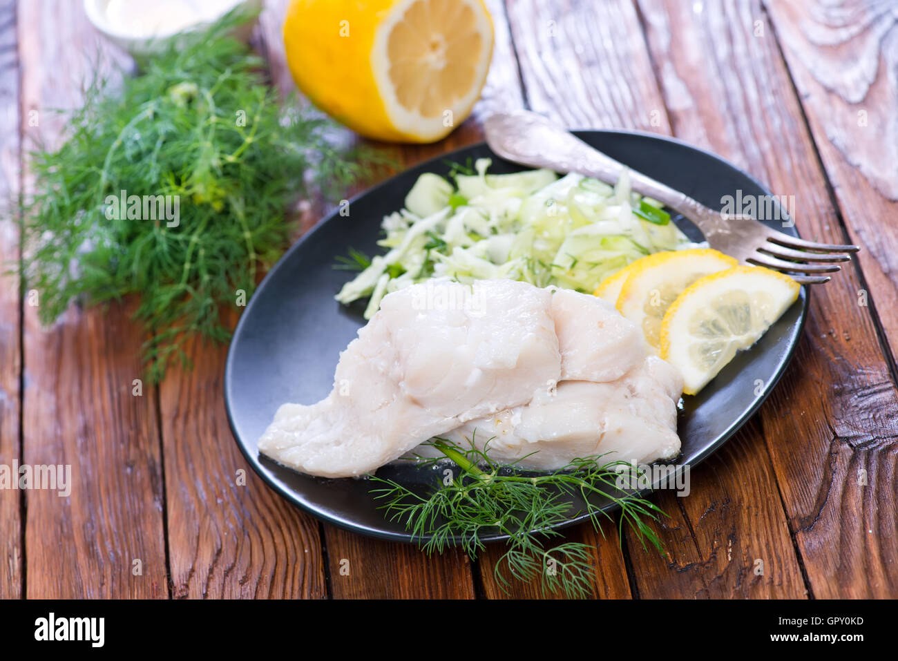 Filet de poisson avec du citron sur la plaque Banque D'Images