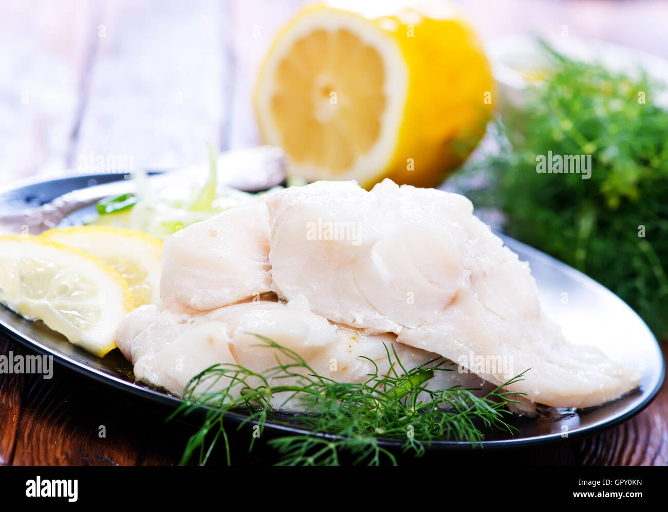 Filet de poisson avec du citron sur la plaque Banque D'Images