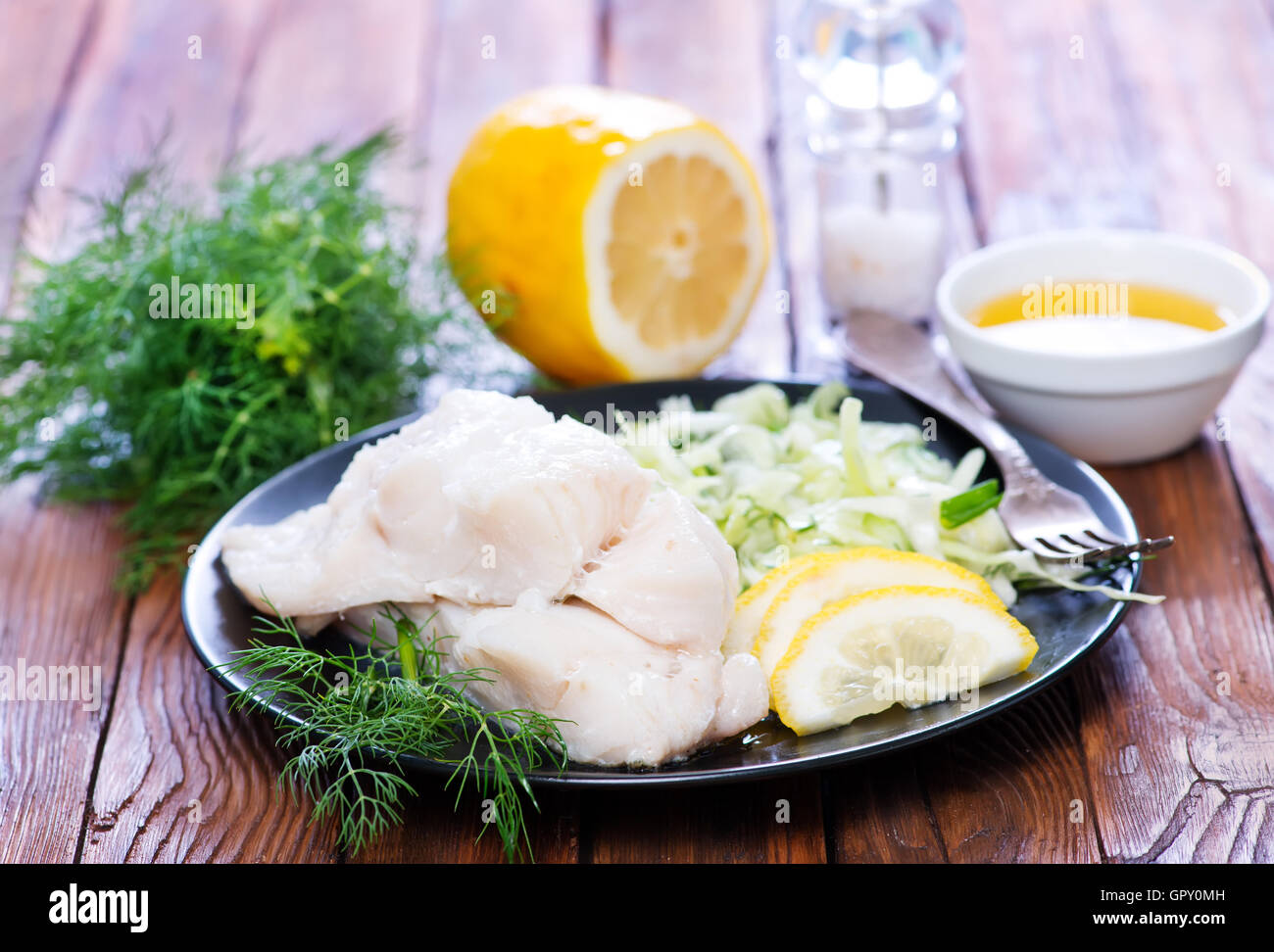 Filet de poisson avec du citron sur la plaque Banque D'Images
