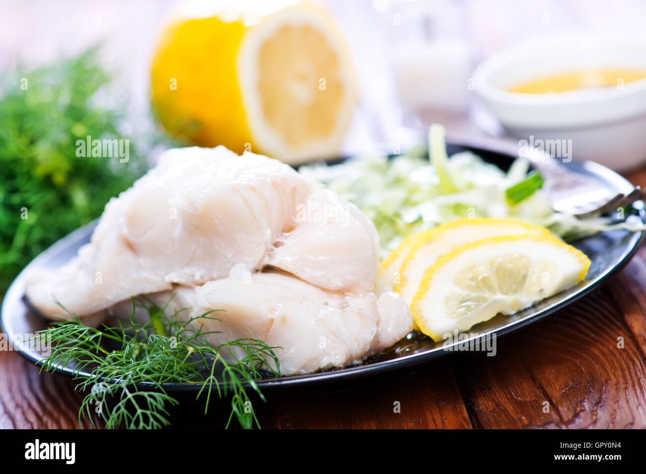 Filet de poisson avec du citron sur la plaque Banque D'Images