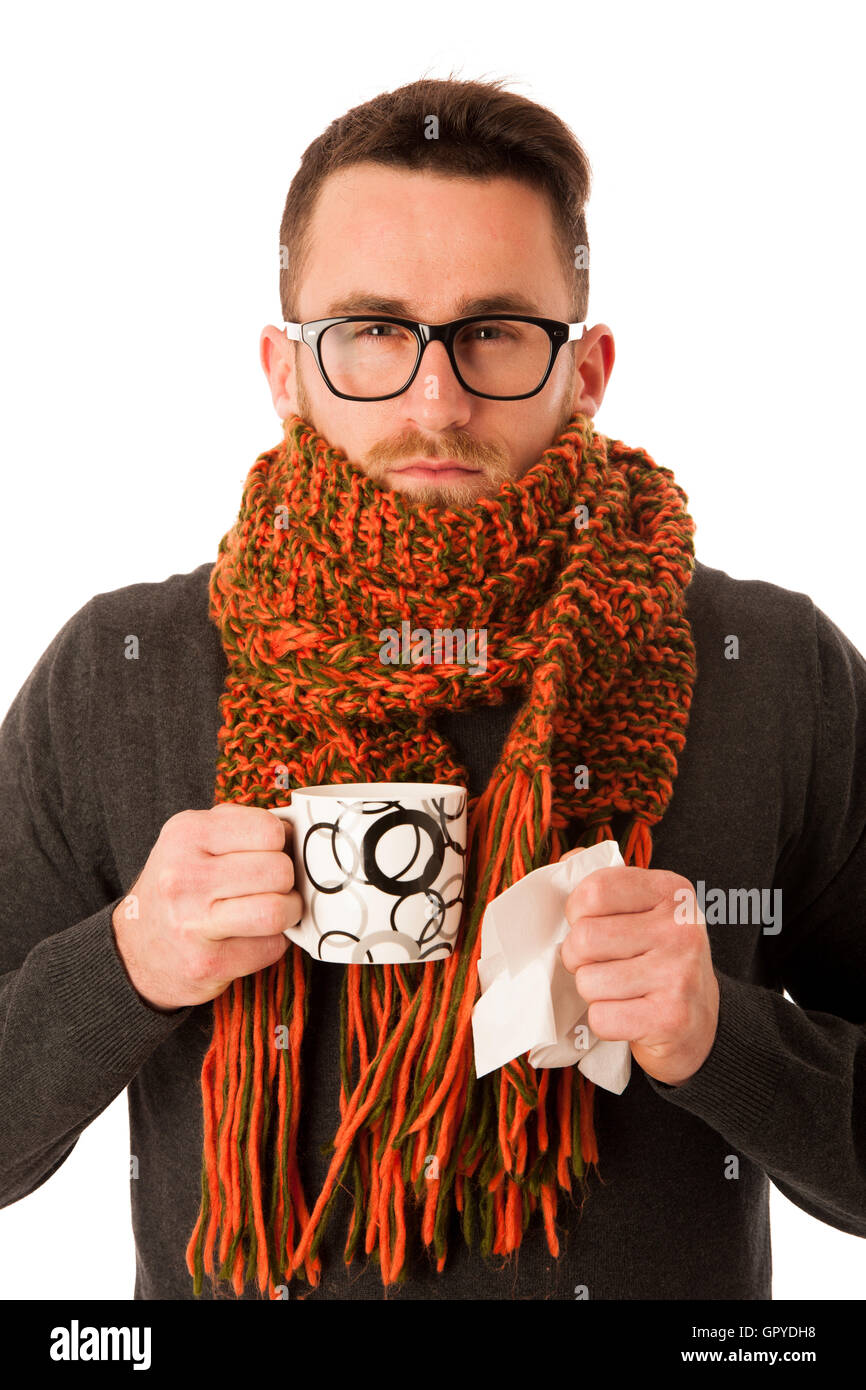L'homme avec la grippe et la fièvre enveloppé dans l'écharpe holding tasse de thé de guérison avec le mouchoir blanc et isolé au-dessus. Banque D'Images