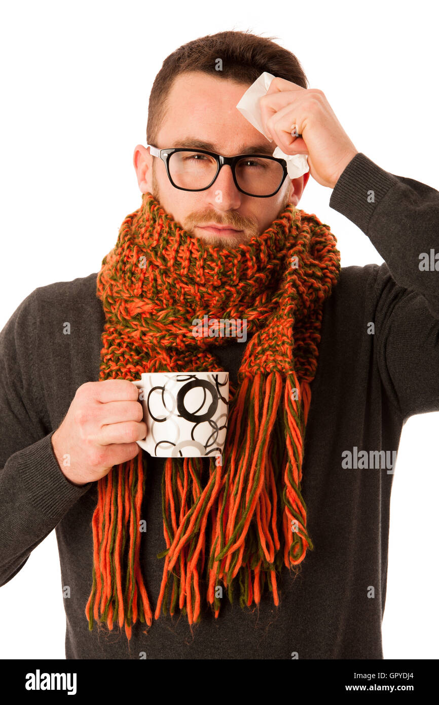 L'homme avec la grippe et la fièvre enveloppé dans l'écharpe holding tasse de thé de guérison avec le mouchoir blanc et isolé au-dessus. Banque D'Images
