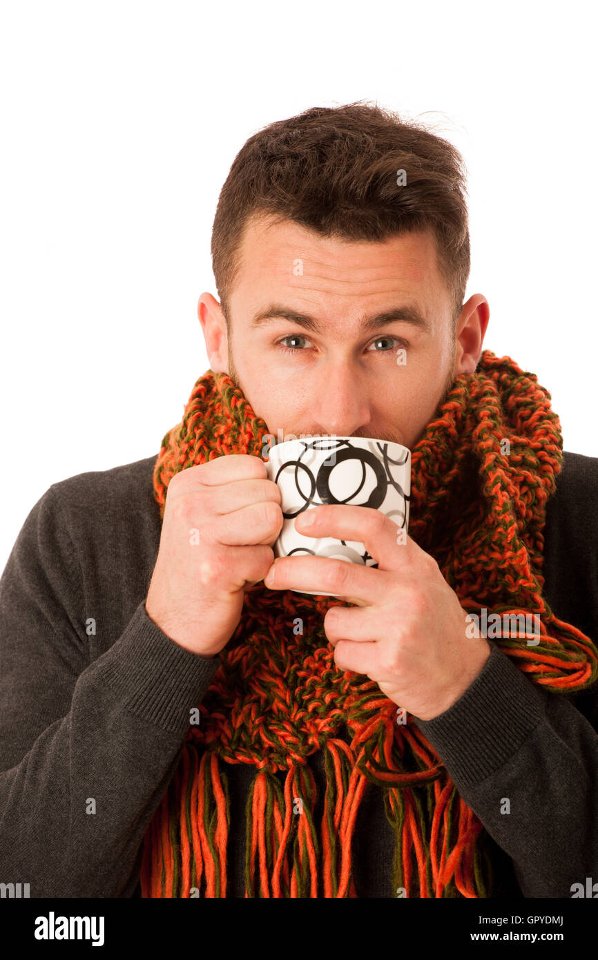 L'homme avec la grippe et la fièvre enveloppé dans l'écharpe holding tasse de thé blanc plus isolés de guérison. Banque D'Images
