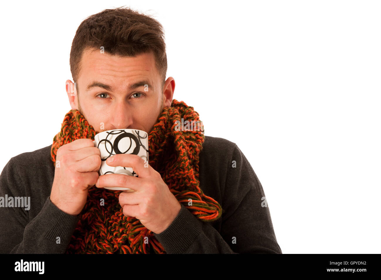 L'homme avec la grippe et la fièvre enveloppé dans l'écharpe holding tasse de thé blanc plus isolés de guérison. Banque D'Images