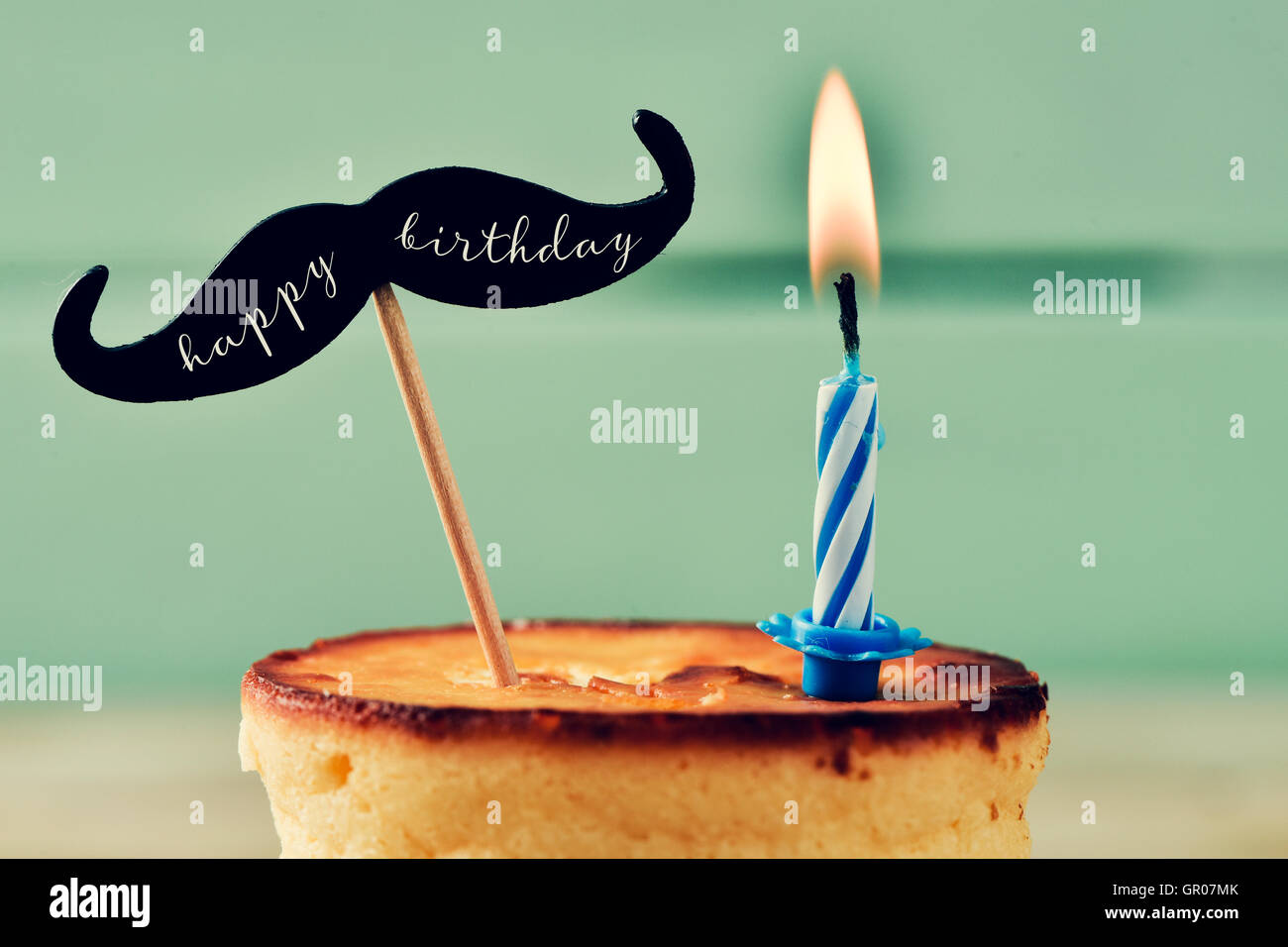 Libre D Un Gateau Au Fromage Surmonte D Une Moustache Avec Le Texte Joyeux Anniversaire Ecrit En C Et Attache A Un Baton Et Un Lit Bi Photo Stock Alamy