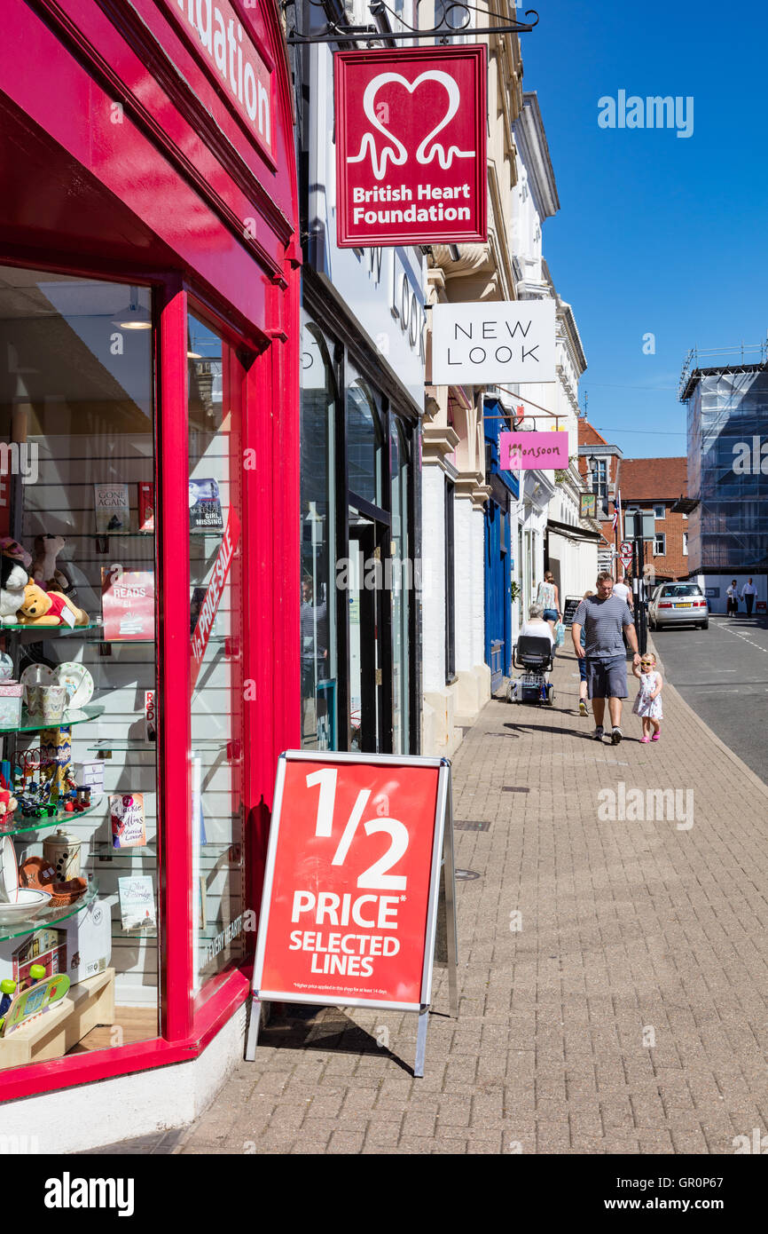 Shop signes en Saffron Walden, et d'un père avec une petite fille s'approcher, Essex, UK Banque D'Images