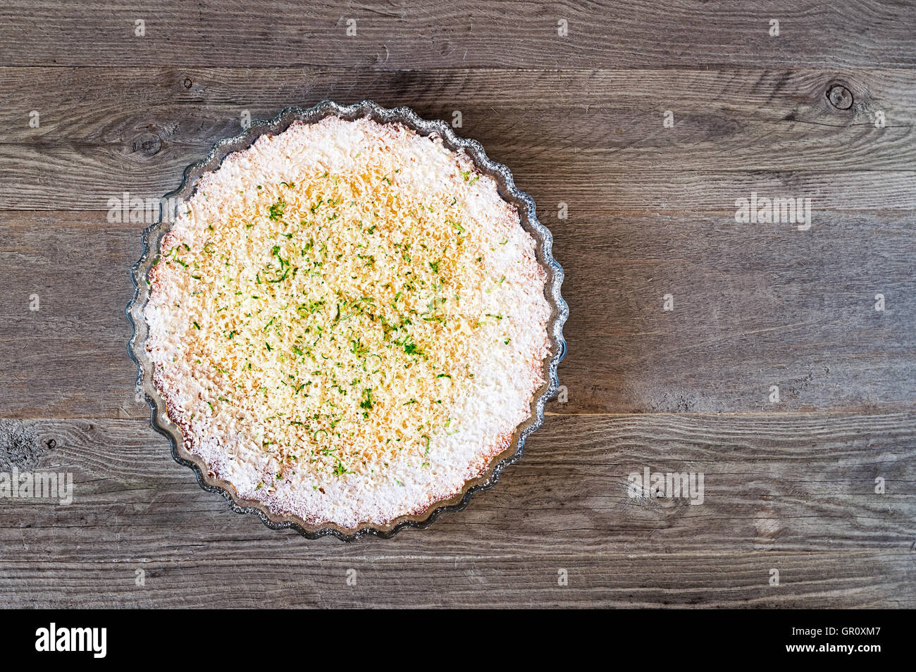 Citron, citron vert, noix de coco tarte impossible avec des copeaux de chocolat blanc sur une table en bois patiné Banque D'Images