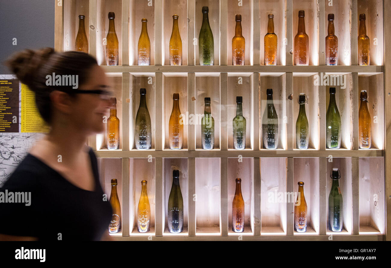 ILLUSTRATION - une vieille femme passe devant les bouteilles de bière dans l'exposition 'Pas de bière sans le lac Alster' au musée de Hambourg à Hambourg, Allemagne, 05 septembre 2016. La brasserie de bière sur le lac Alster a une tradition à Hambourg Hambourg - Le Musée propose une exposition sur le thème de la bière à partir 07 septembre 2016. Photo : DANIEL BOCKWOLDT/dpa Banque D'Images