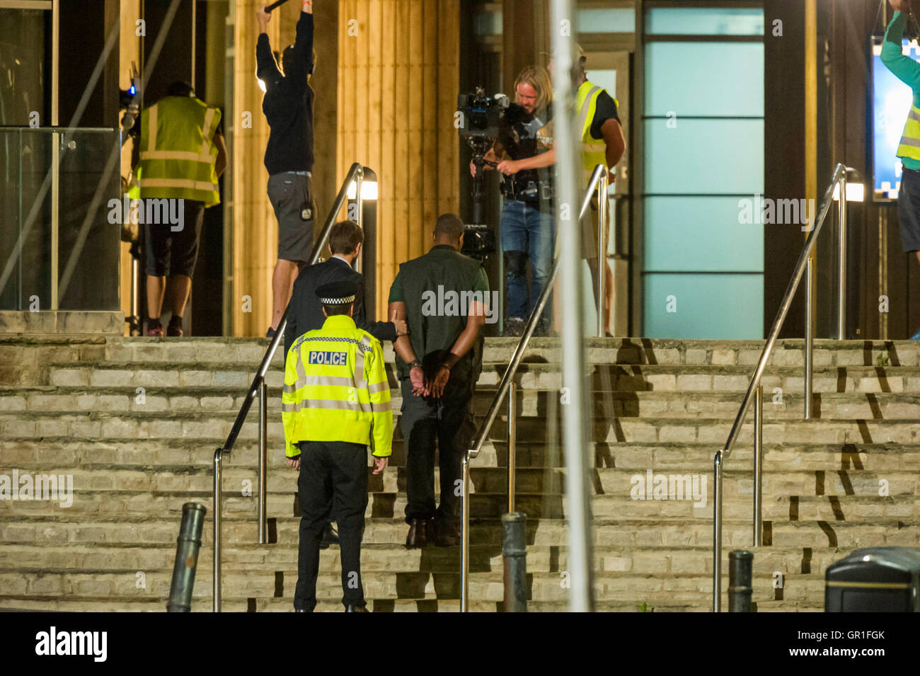 West Bay, Dorset, UK - 6 septembre 2016 - David Tennant et Sir Lenny Henry tournage scène d'arrestation sur les marches de la station de police de nuit pour la série 3 de la série à succès d'ITV Broadchurch. Ed Burnet, le personnage joué par Sir Lenny Henry est considéré d'être placés en détention en menottes par DI Alec Hardy joué par David Tennant, après qu'il avait agressé l'un de l'affiche les caractères Jim Atwood. Photo : Graham Hunt/Alamy Live News Banque D'Images