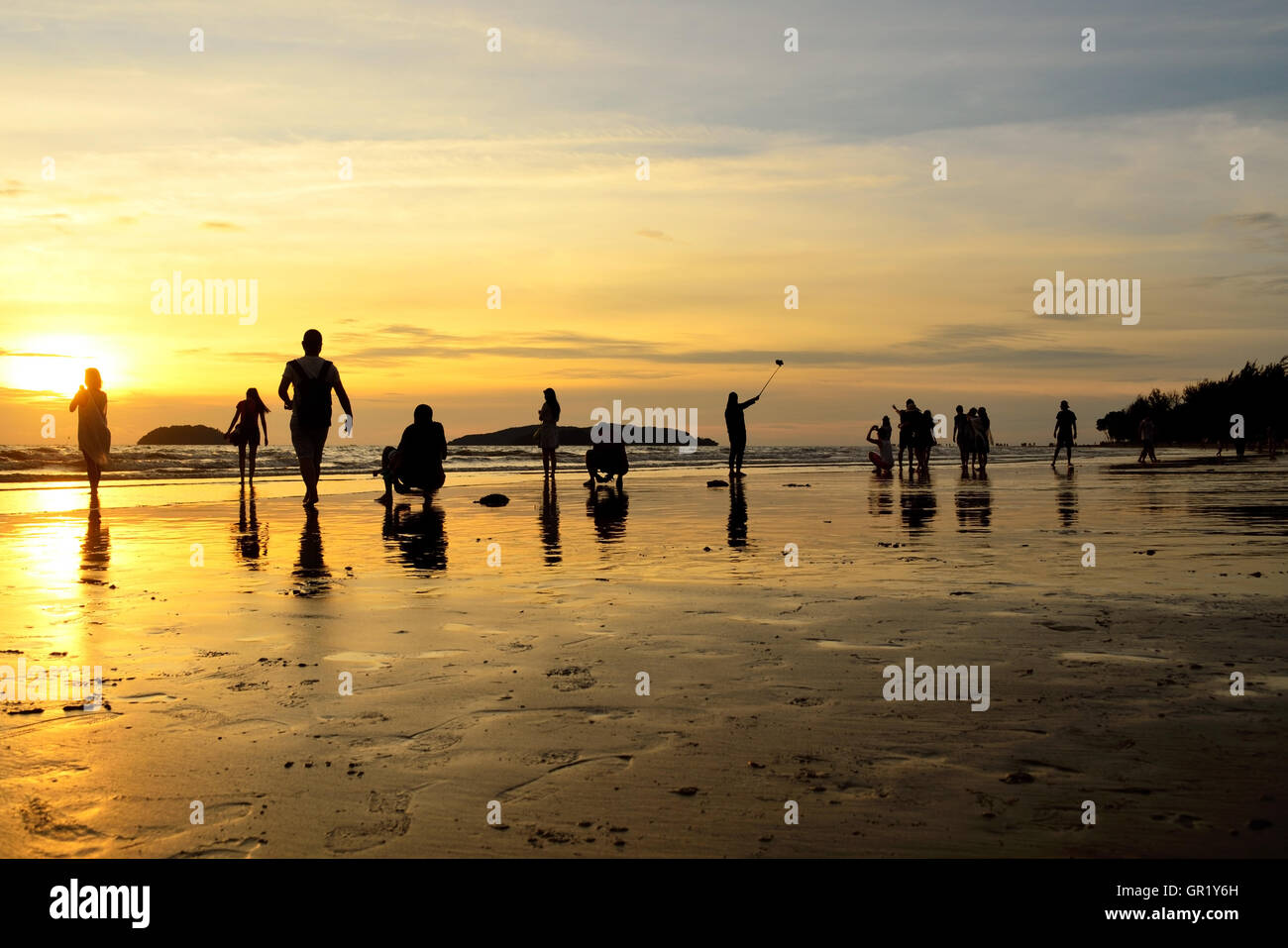 Silhouettes d'habitants et les touristes pour le coucher du soleil sur la plage de Tanjung Aru, Kota Kinabalu, Sabah. La plage de Tanjung Aru dans l'un des t Banque D'Images