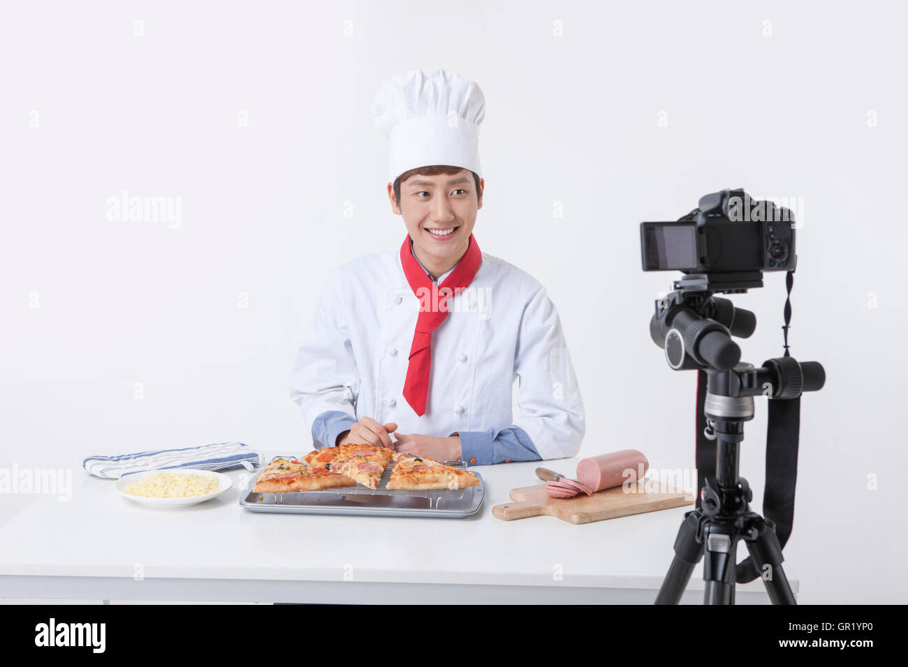 Portrait of young male cook posant devant une caméra vidéo Banque D'Images