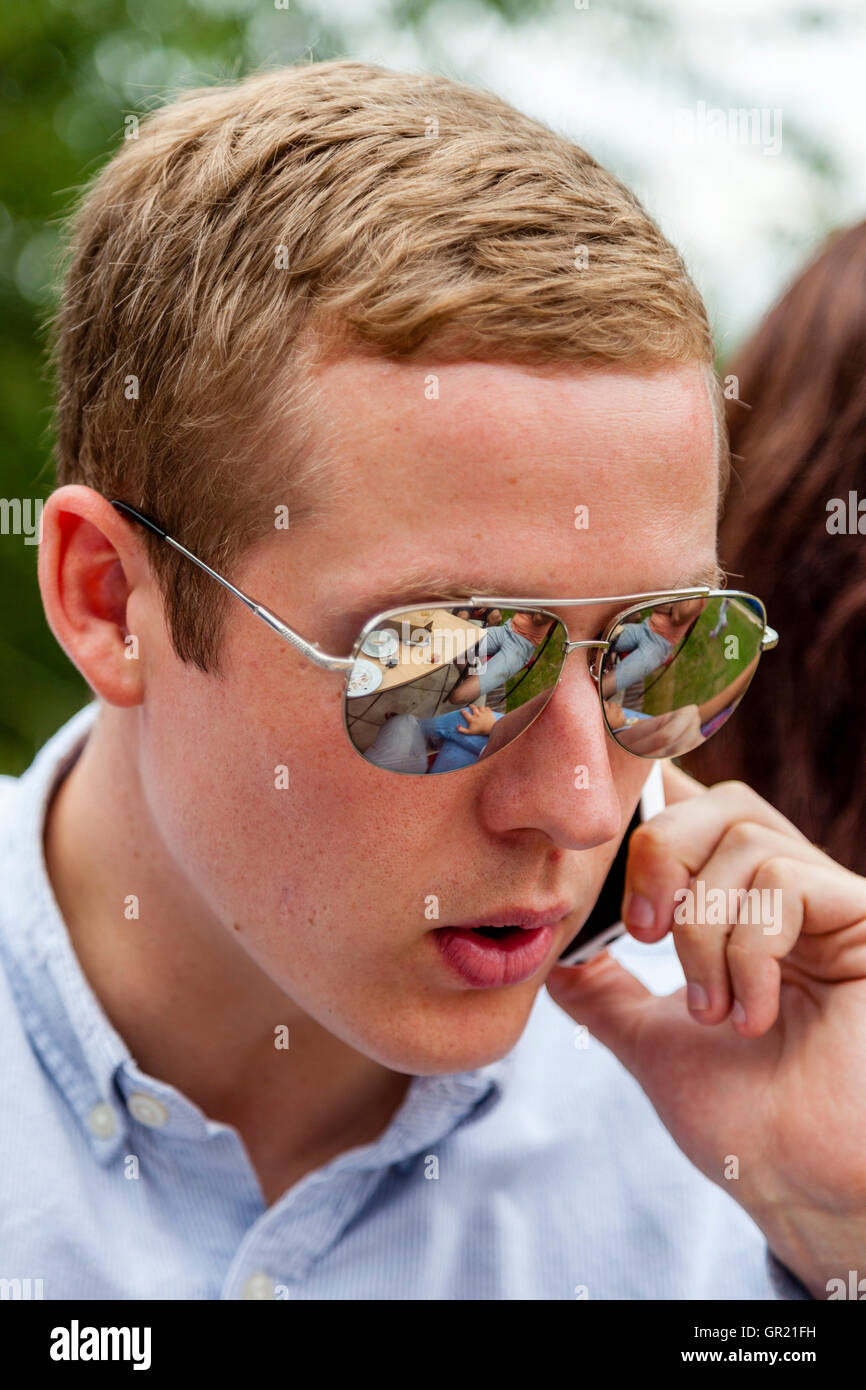Un beau jeune homme à l'aide d'un téléphone mobile, Sussex, UK Banque D'Images