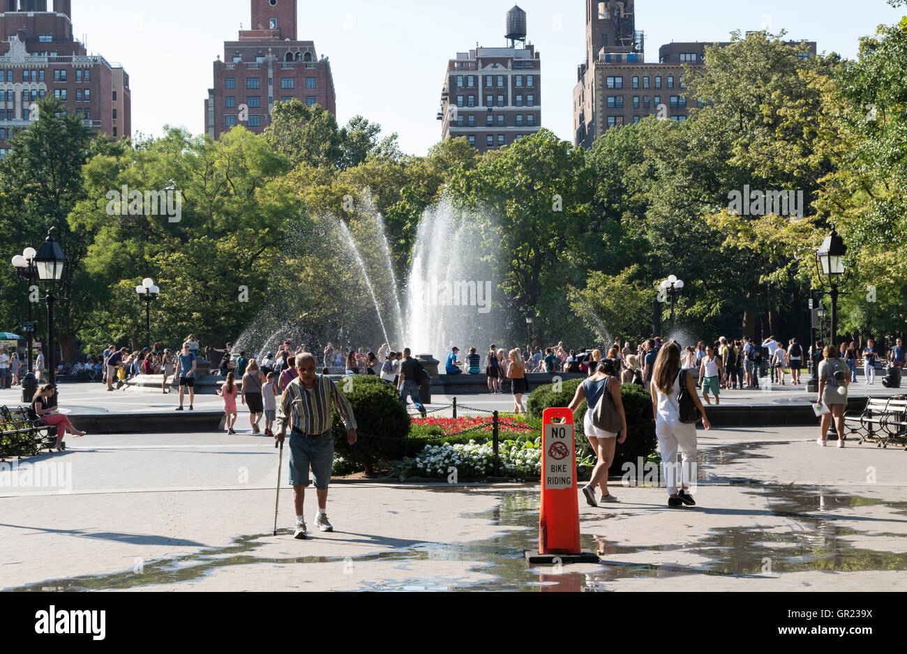 Washington Square Park en été avec des personnes appréciant la chaleur autour de la fontaine d'eau. Banque D'Images