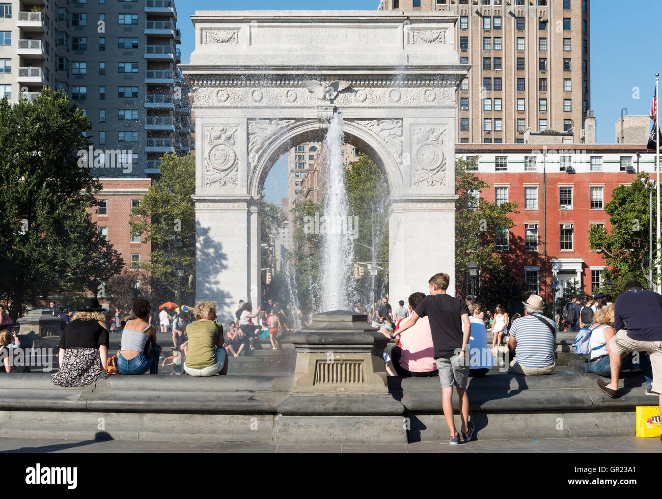 Washington Square Park en été avec des personnes appréciant la chaleur autour de la fontaine d'eau. Banque D'Images